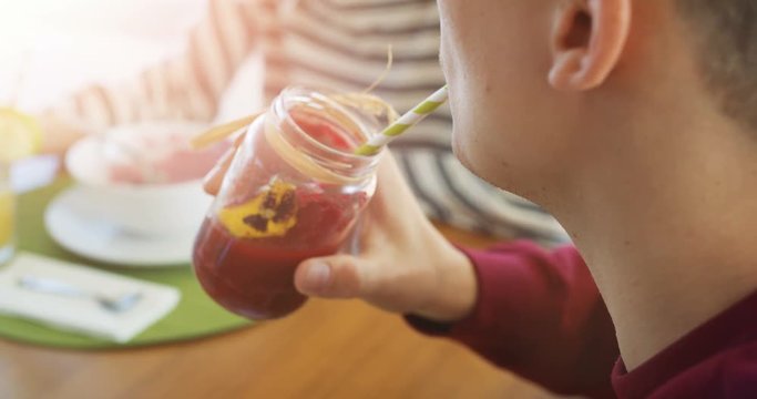 Close-up Shot of a Man Drinking Healthy Smoothie from a Stylish Jar Through a Straw.  Shot on RED Epic 4K UHD Camera.