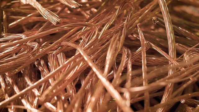 bare wires of copper cables are lying in a heap of scrap metal in factory premise, close-up shot