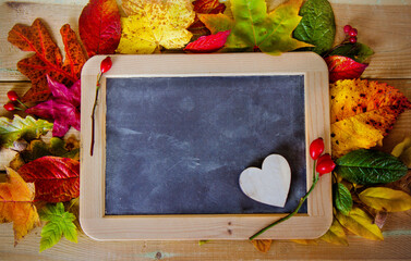blackboard with autumn leaves on the table