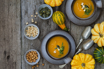 Creamy pumpkin soup topped with pumpkin seeds close-up