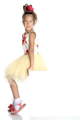 A little girl is looking from behind an empty banner.