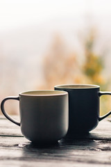 Still life with cup of coffee on the carpathian mountains background during the sunset