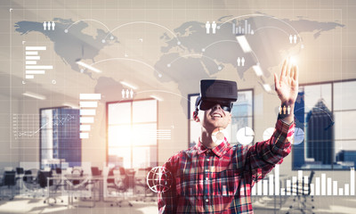 Young man in modern office interior experiencing virtual reality