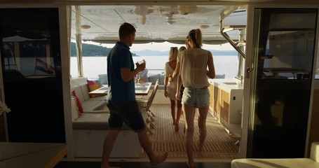 Group of Successful Young People Join Others in the Stern of the Yacht with Cocktails