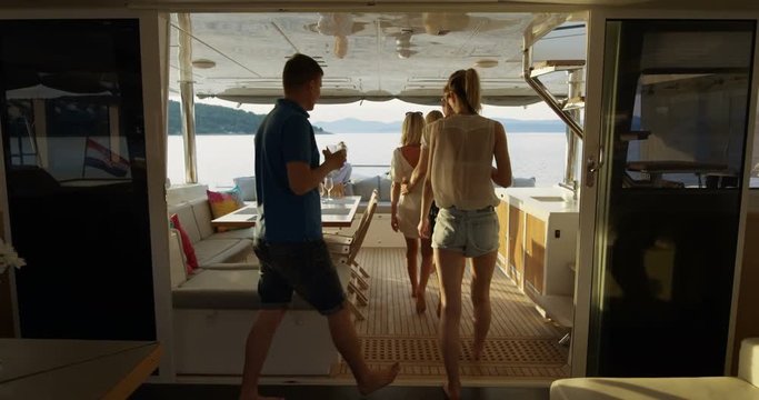Group of Successful Young People Join Others in the Stern of the Yacht with Cocktails