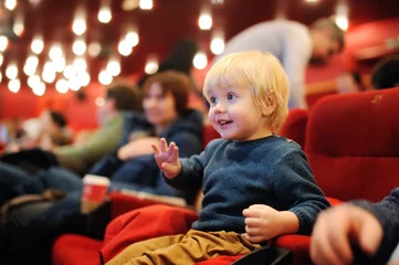 Foto op Aluminium Cute toddler boy watching cartoon movie in the cinema © Maria Sbytova
