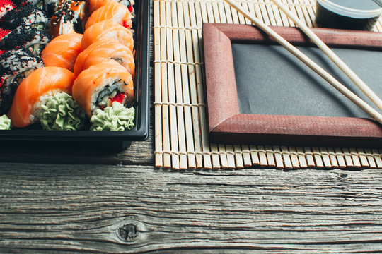 on the table are in the black container, sushi set with photo frame