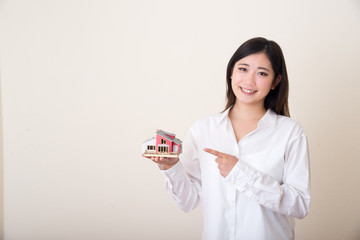 young asian woman with miniture house