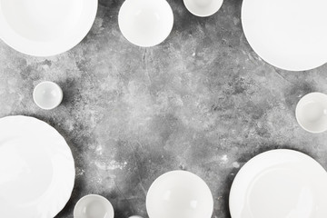 Clean white tableware on a gray background. Top view, copy space