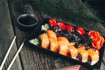 on the table are in the black container, sushi set with photo frame and Christmas attributes