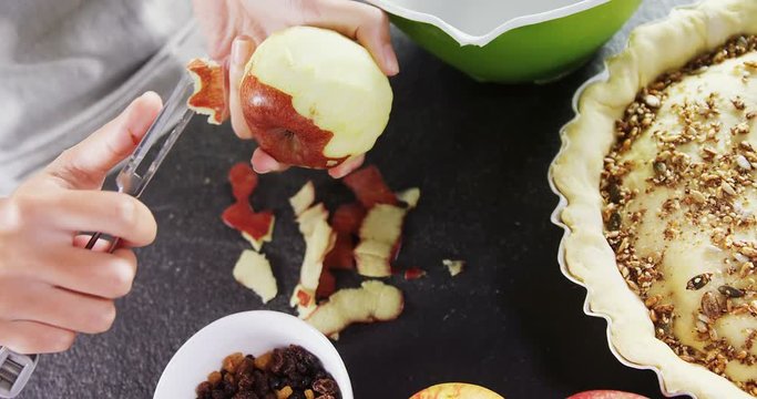 Woman pealing off apple skin 