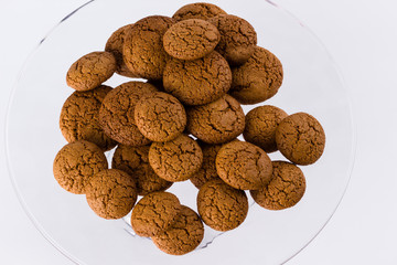 pile of homemade speculaas (type of spiced biscuit made of brown sugar & cinnamon) for the St Nicholas day (Sinterklaas) on white background