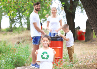 Family throwing garbage into litter bin outdoors. Recycling concept