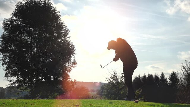 Golf Player plays golf on a beautiful summer morning. wide angle Lens flare Back lite shot 