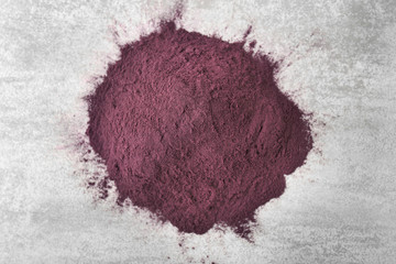 Heap of acai powder on gray background