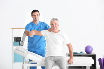 Obraz premium Physiotherapist working with senior patient in modern clinic