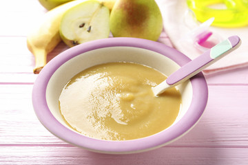Bowl with baby food on table