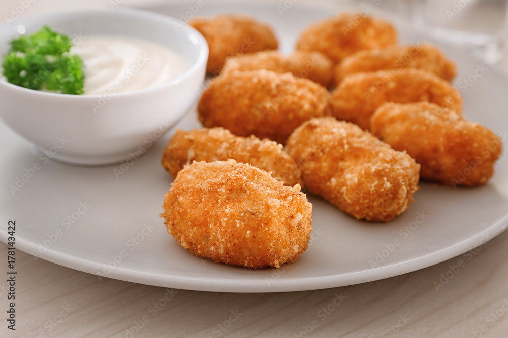 Sticker plate with delicious salmon croquettes on table, closeup