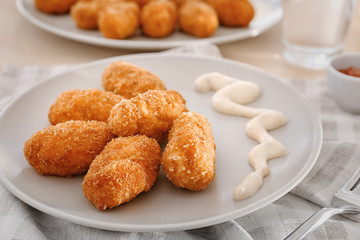 Plate with delicious salmon croquettes on table