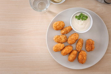 Plate with delicious salmon croquettes on table
