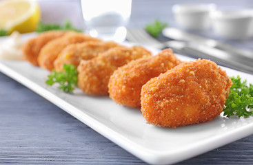 Plate with delicious salmon croquettes on table, closeup