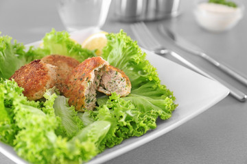 Plate with delicious salmon patties on table, closeup