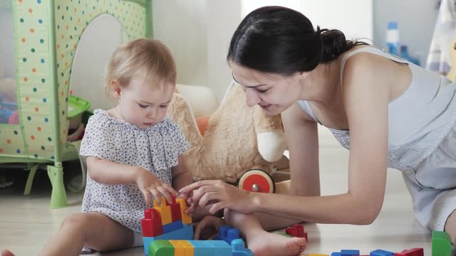 child little girl playing wooden toys at home or kindergarten, baby kid intellectual games children's desinger with mom mother