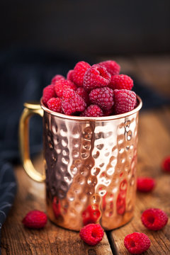 Fresh ripe raspberries in a copper mug