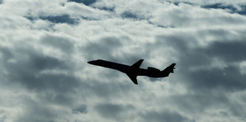 Fototapeta na wymiar Jet Airplane Silhouette With White Cloud Background