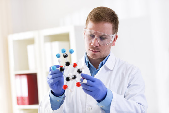 Young scientist holding molecular model