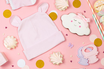 Sweets, baby clothes and accessories on the pink background