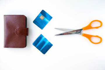 Flat lay view of a  pair of scissors with a cut credit cared and a wallet