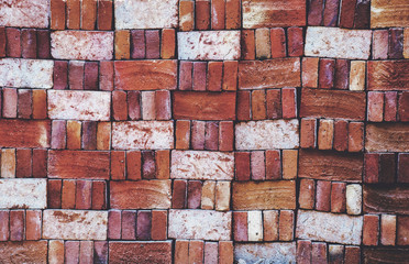 Pile of locally produced and neatly arranged red bricks creates a pattern