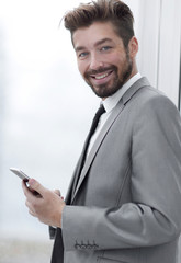 Obraz na płótnie Canvas Stylish man in suit is reading information on phone