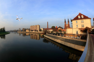 Samolot sterowany radiowo przelatuje nad Opolem i rzeką Odrą.