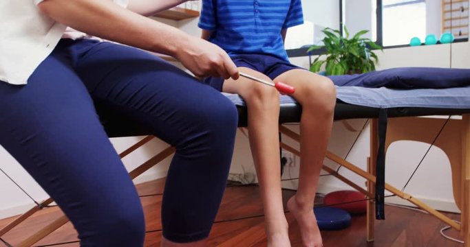 Doctor examining reflexes of patient knee 