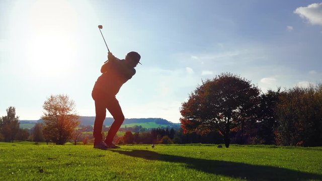 Golf Player plays golf on a beautiful summer morning. wide angle Lens flare Back lite shot 