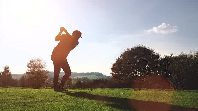 Casual Urabn Golf Player plays golf on a beautiful summer morning. wide angle Lens flare Back lite shot 