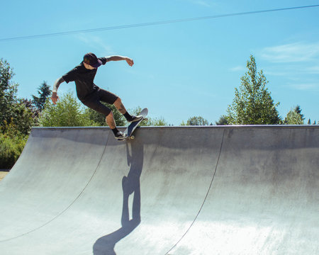 A young man performs a skateboard trick on a ramp