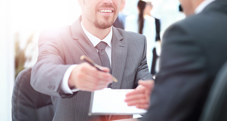 Businessman giving a pen to seal  deal with his partner