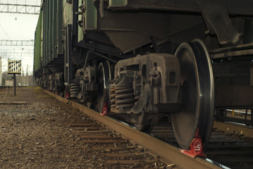 A bogie of freight railcar closeup, with brake shoe put under the wheel