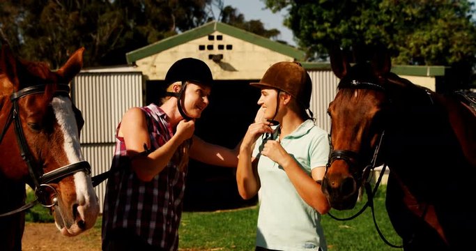 Friends interacting while wearing protective helmet in ranch 
