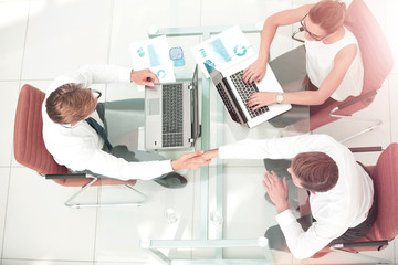 Image of business partners making handshake. Top view.