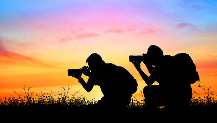 Silhouette of photographer with his camera on light pastel background.
