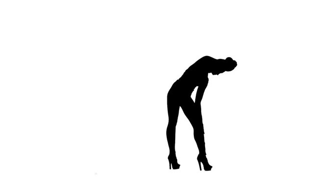 Fashion model is sexually wriggling her body. Silhouette. White background. Slow motion