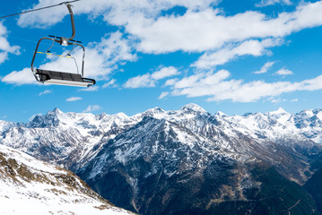 Chairlift against snowy Alpine mountains