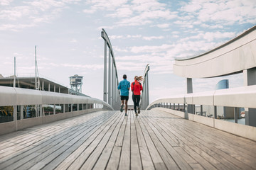 Young multi ethnic couple running on the bridge.