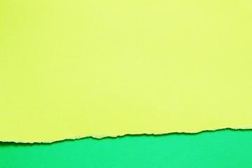 yellow ripped paper on green paper background. copy space