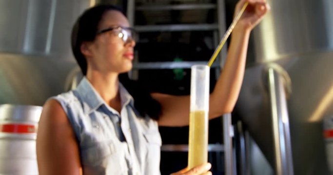 Female brewer testing beer 