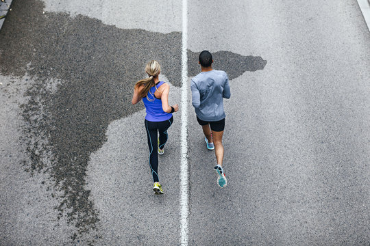Aerial view of young couple running on a urban road.
